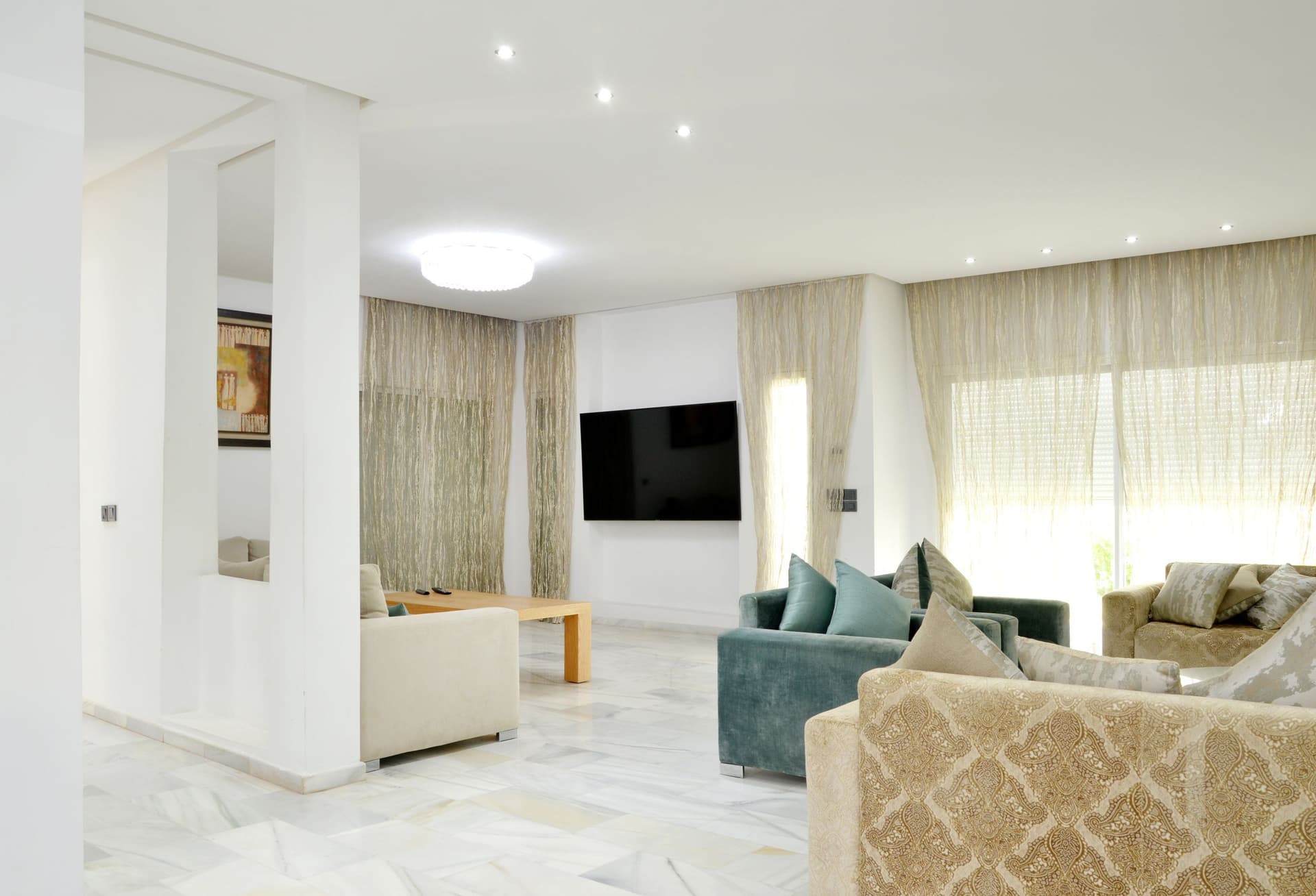 Spacious, spotless living room with polished marble floors and bright natural light